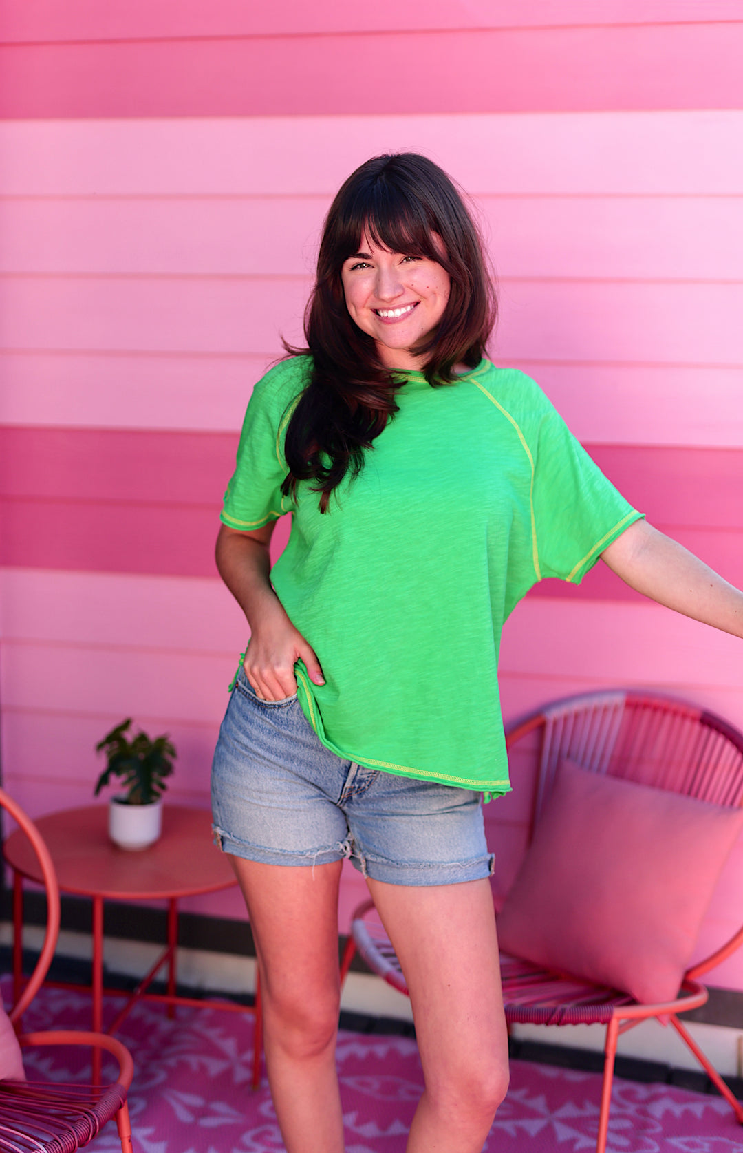 Bright green casual tee with yellow trim, paired with denim shorts, perfect for summer outings.