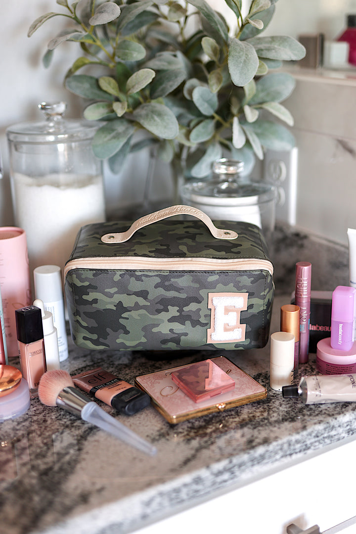 Camouflage makeup bag with handle and initial E, perfect for organizing beauty products.