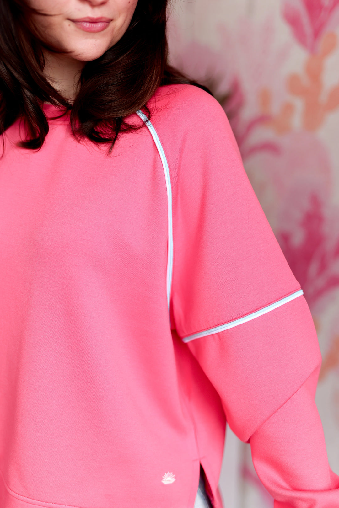 Women’s pink pullover sweatshirt with white piping, ideal for casual wear or workouts.