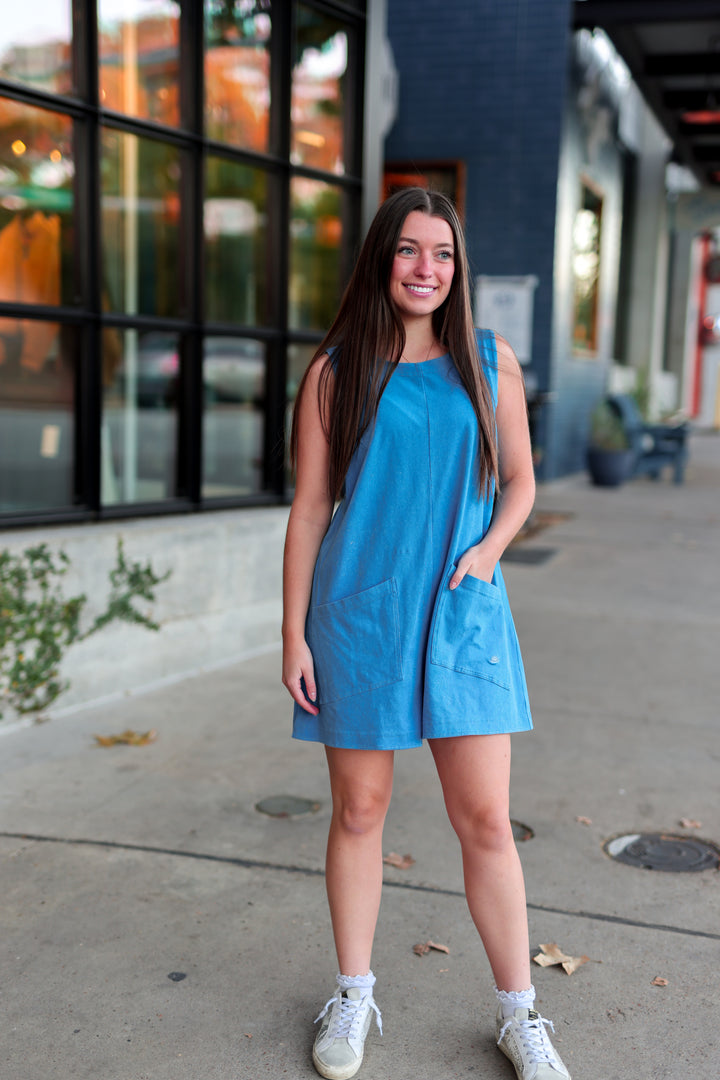 Light blue sleeveless romper with front pockets, perfect for casual summer outings.