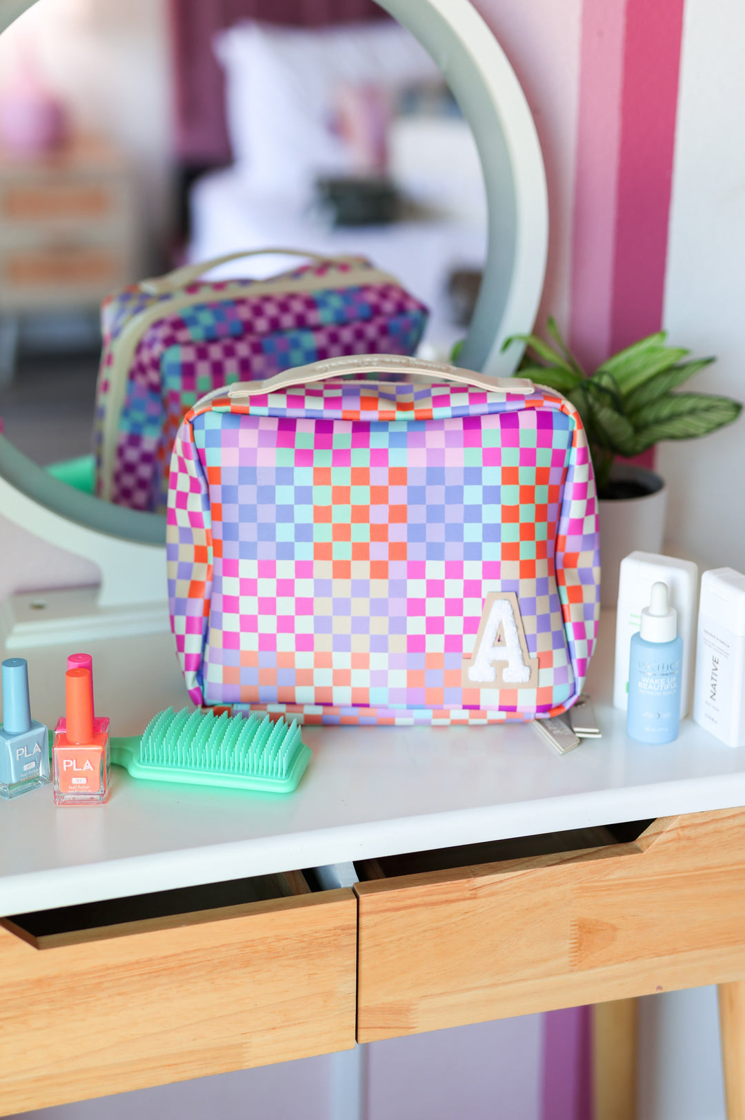 Colorful checkered makeup bag on a vanity with various items