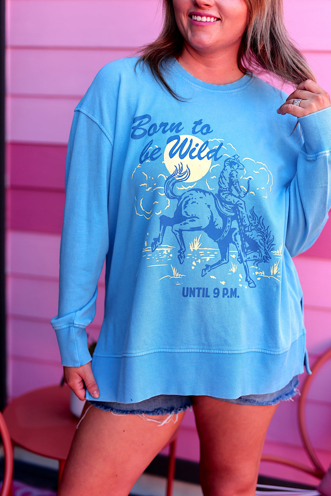 Light blue oversized sweatshirt featuring 'Born to be Wild' graphic and horse design, perfect for casual wear.