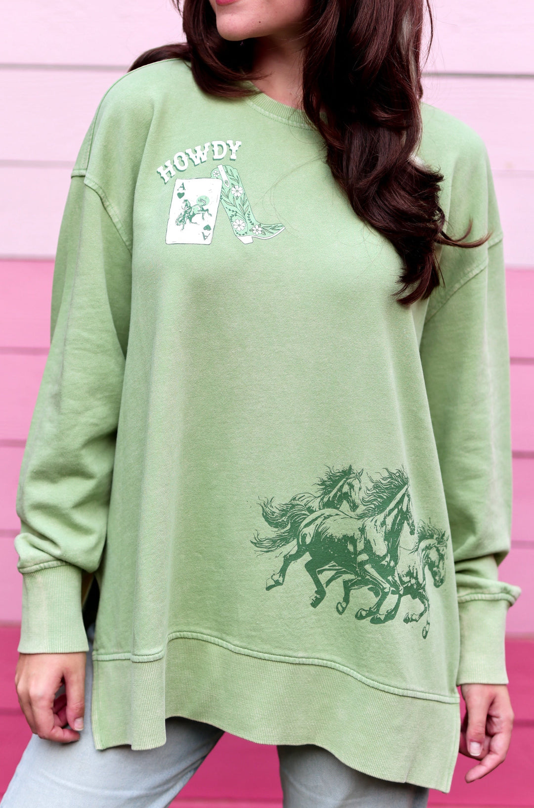Green oversized sweatshirt featuring wild horses graphic and 'Howdy' print, perfect for casual wear.