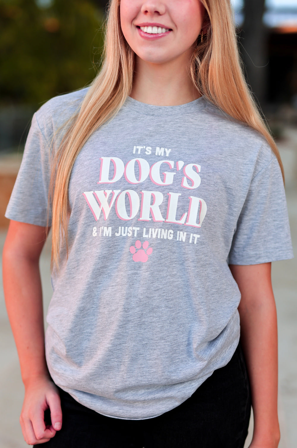 Person wearing a gray t-shirt with text outdoors