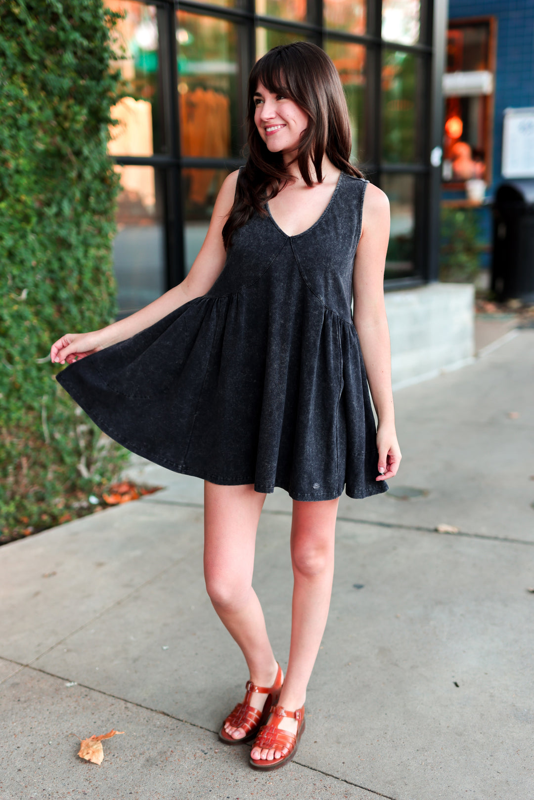 Woman in flowy black dress standing outside.