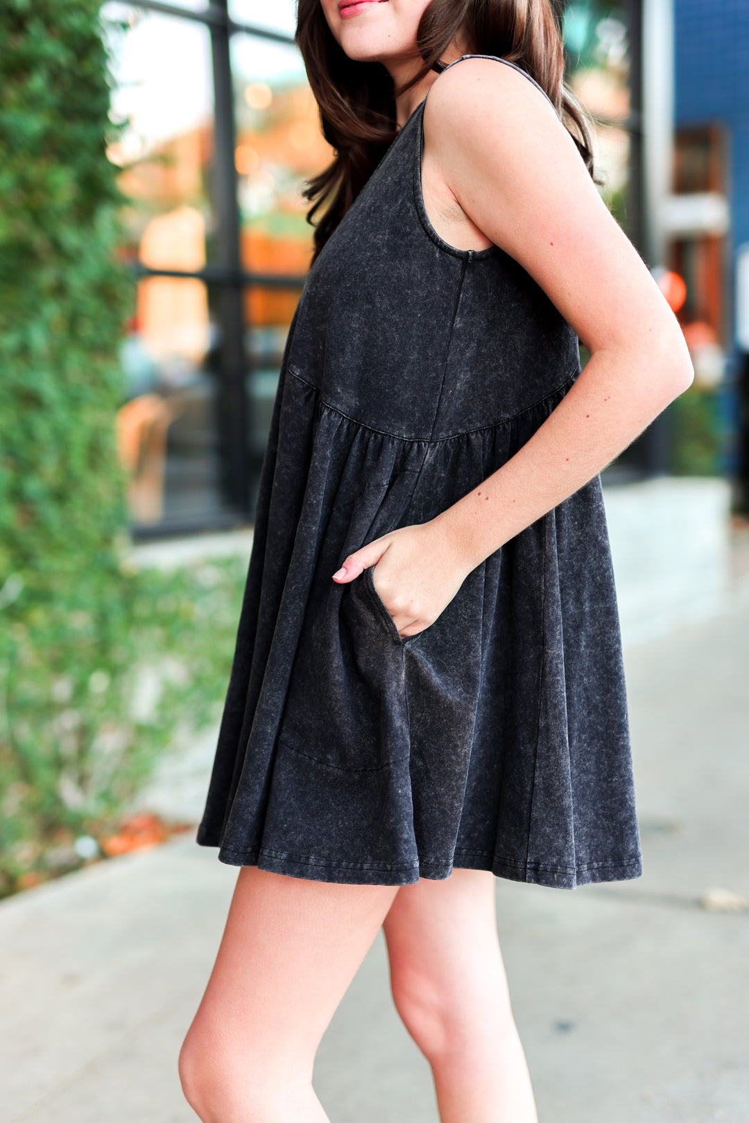 Women’s sleeveless black cotton dress with pockets and flared hem for a stylish and comfortable look.