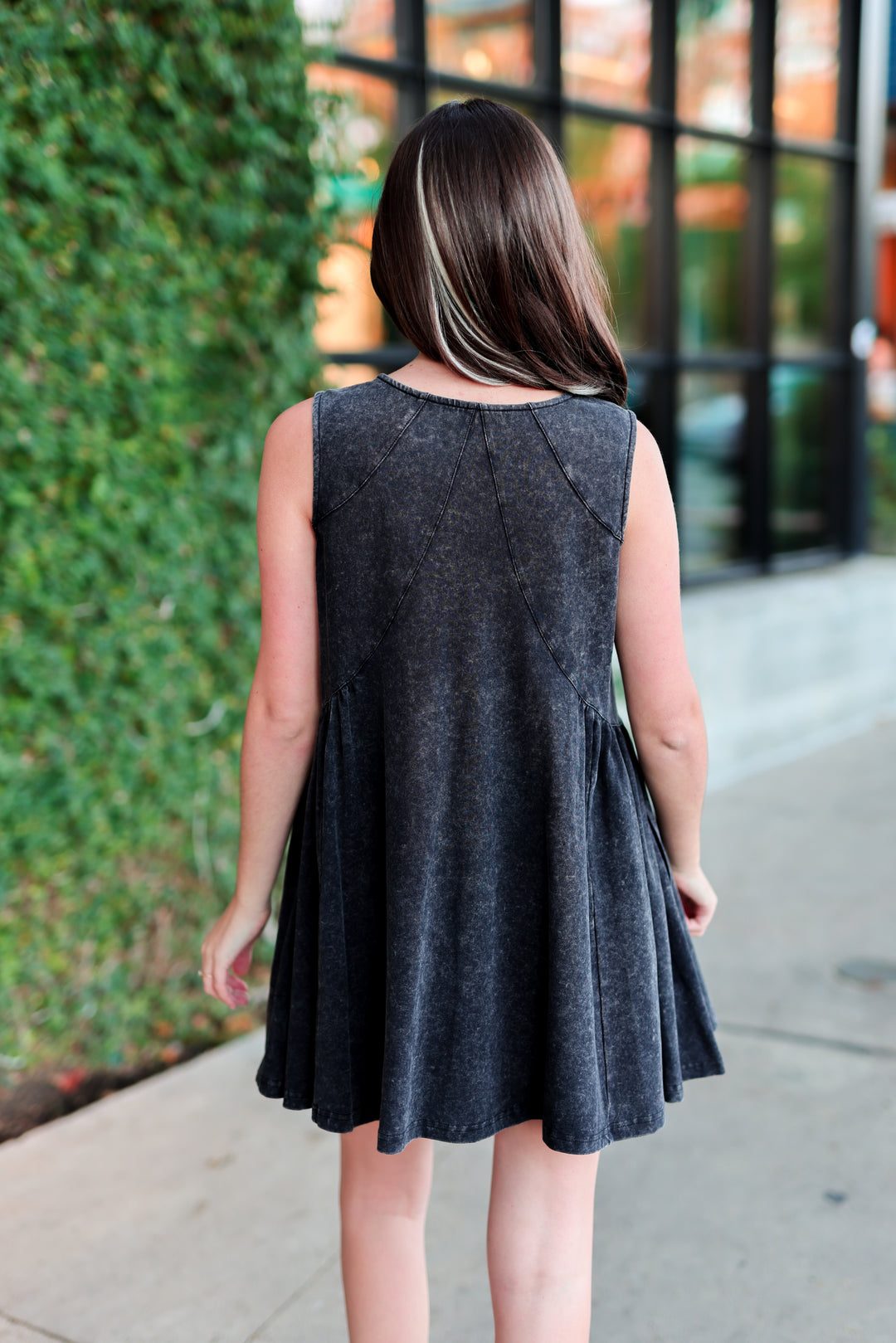Back view of a sleeveless gray denim dress with a flared skirt, perfect for casual outings.