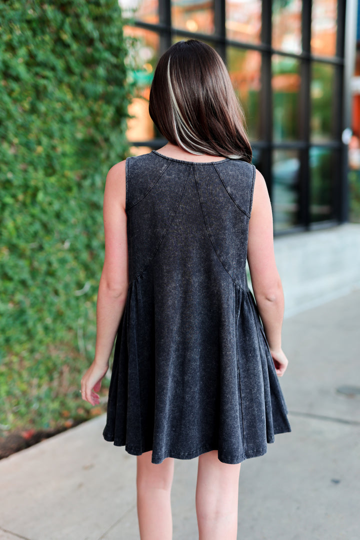 Back view of a sleeveless gray denim dress with a flared skirt, perfect for casual outings.