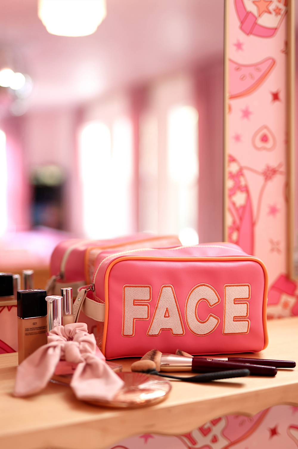 Pink makeup bag with 'FACE' design, spacious, perfect for cosmetics and brushes, stylish travel accessory.