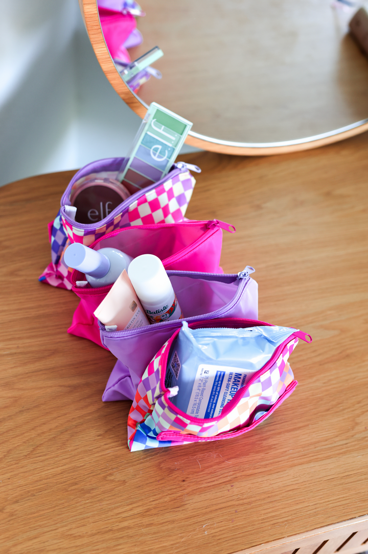 Colorful cosmetic bags in pink and purple, perfect for organizing makeup and skincare essentials.