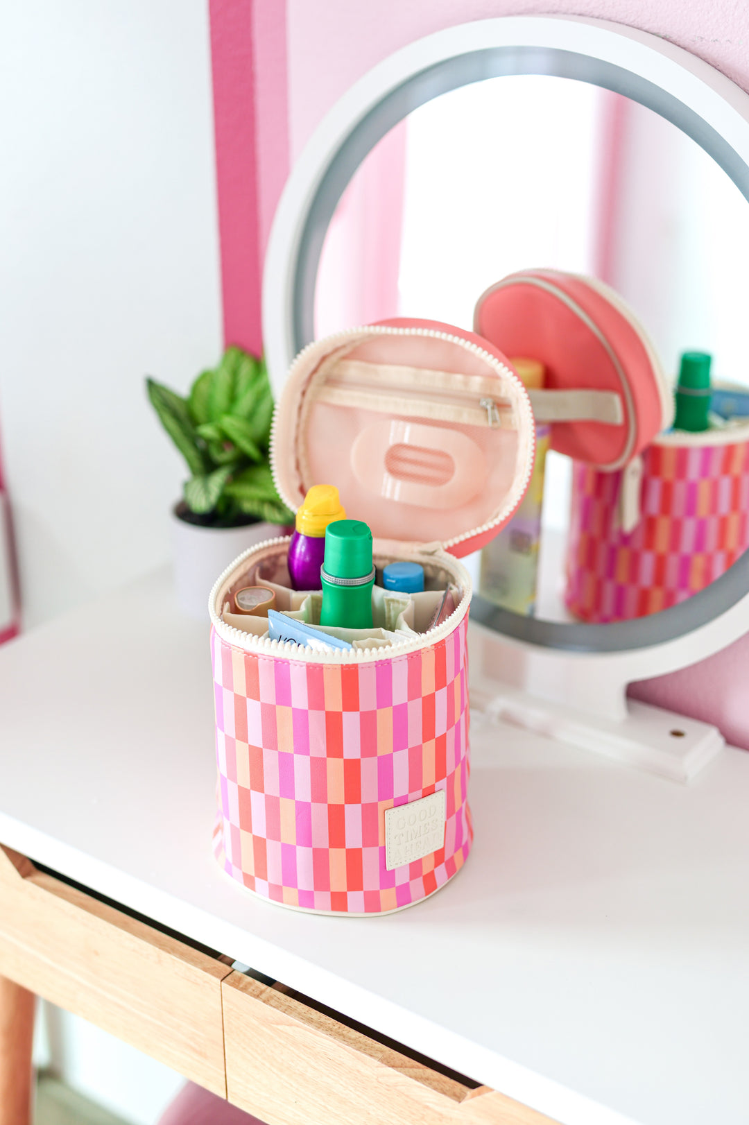 Colorful checkered makeup organizer bag in pink and orange, made of durable material with multiple compartments.