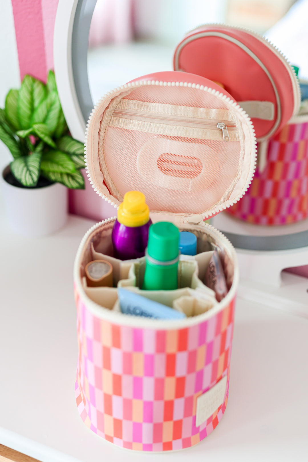 Colorful checkered cosmetic bag with multiple compartments for organizing beauty products.