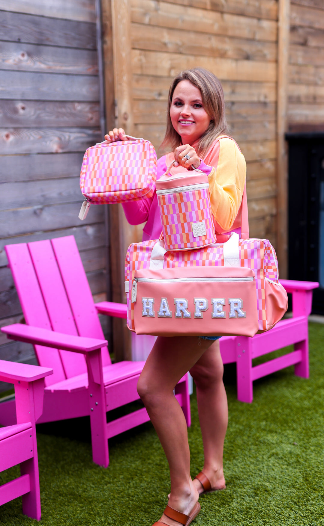 Colorful pink checkered travel bag set including duffel, lunchbox, and matching pouch.