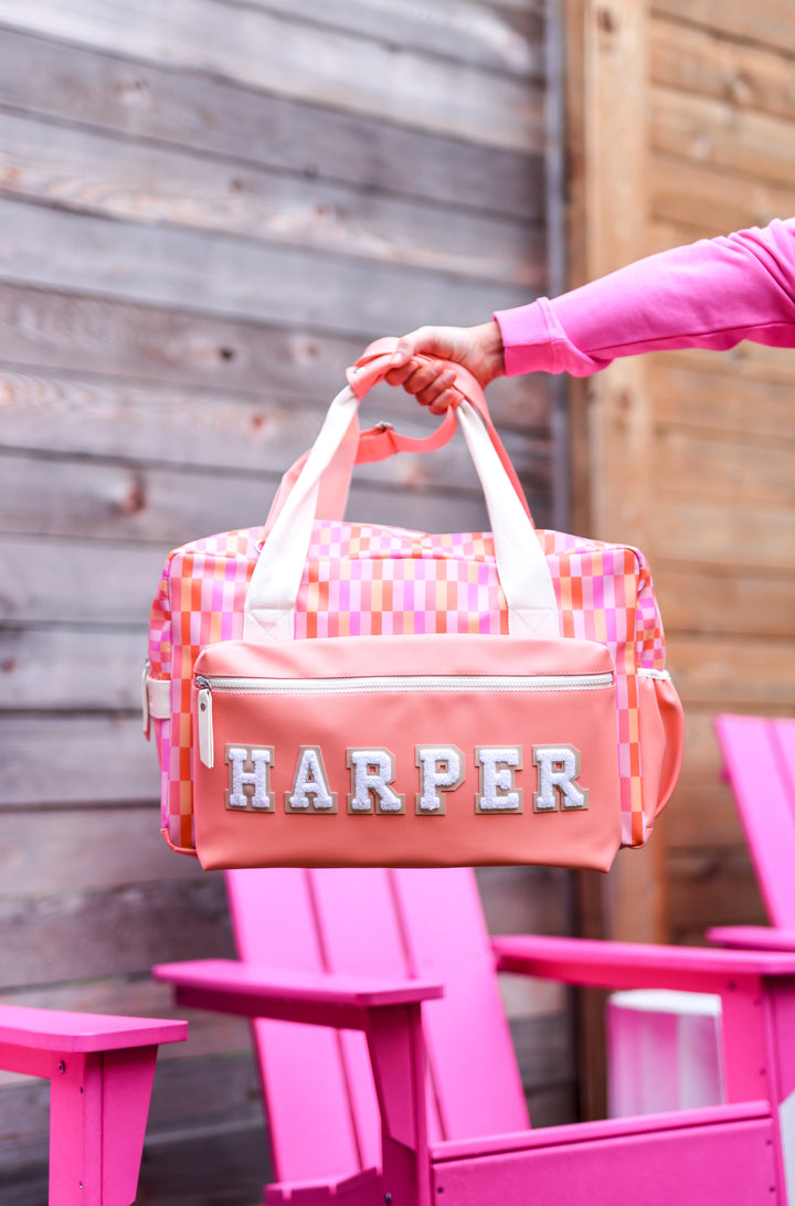 Colorful pink chequered duffel bag with personalized name 'HARPER', ideal for travel or gym.