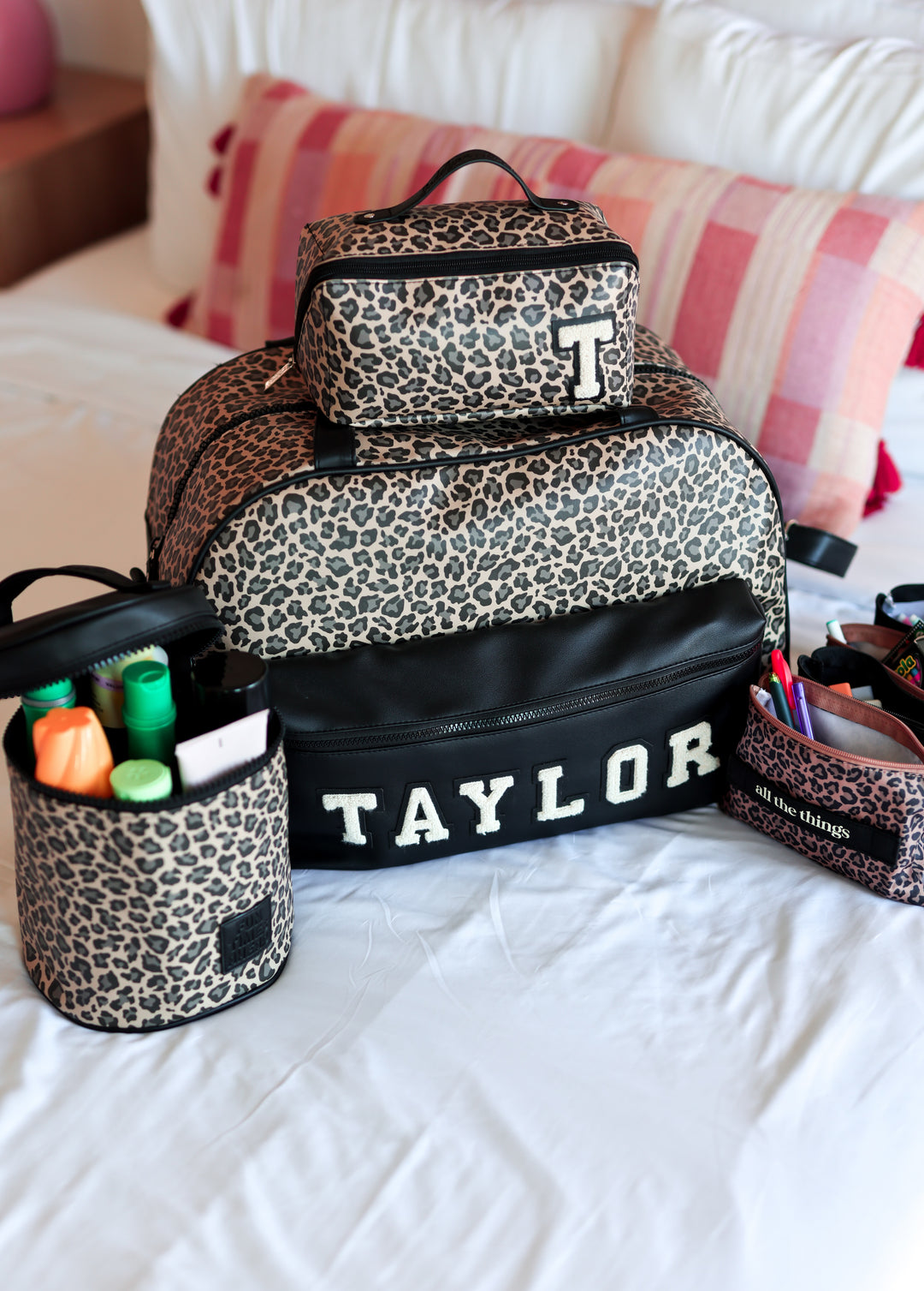 Leopard print duffle and accessories on a bed