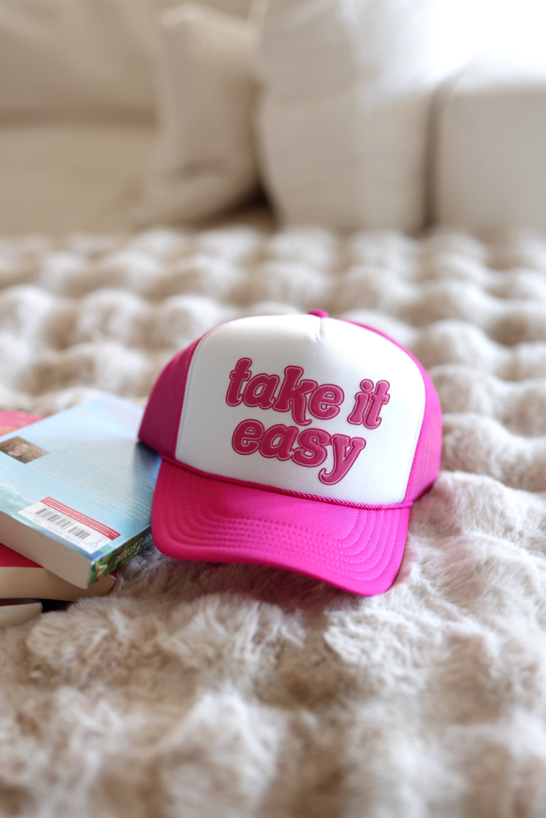 Pink and white cap with 'take it easy' text on a textured surface