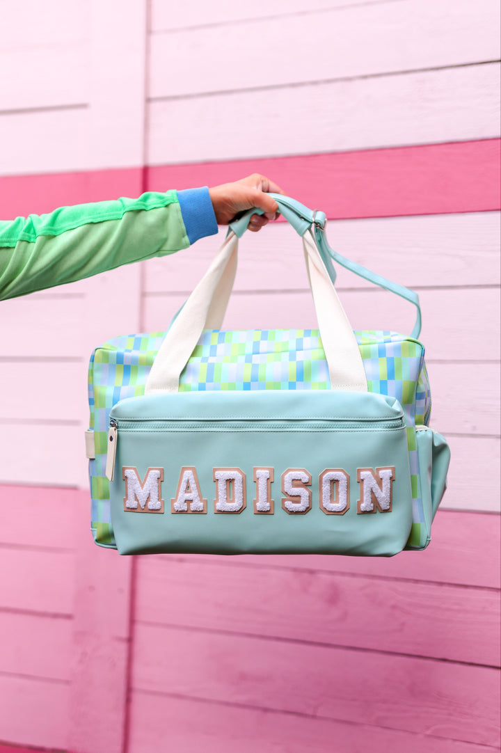 Colorful Madison duffel bag with mint green and patterned design, durable material, perfect for travel.