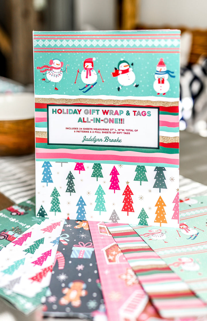 Holiday gift wrap set with 24 sheets and tags featuring festive designs, including snowmen and Christmas trees.